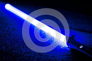 Blue light Sword Saber Laying on Carpet Floor