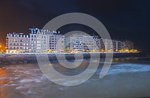 Blue lighting on the Urumea river, Cantabrian sea and the buildings of the city of Donostia