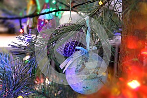 A blue and lilac ball on a Christmas tree. We celebrate New Years Eve. card. Background.