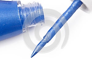 Blue liquid eyeliner brush close-up macro with a tube