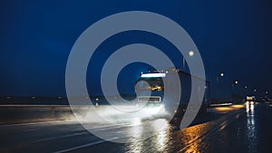 Blue Long Haul Semi-Truck with Cargo Trailer Full of Goods Travels At Night on the Freeway Road