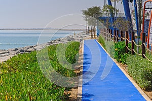 Blue long running track on embankment with special high technology surface for walking and jogging exercise.