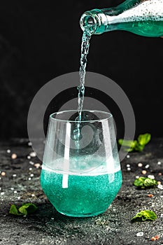 Blue low alcohol drink, chilled colorful beverages on rustic black background. summer party. Alcoholic drink concept. Freeze