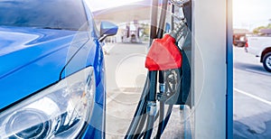 Blue luxury SUV car fueling at gas station. Refuel fill up with petrol gasoline. Petrol pump filling fuel nozzle in gas station.