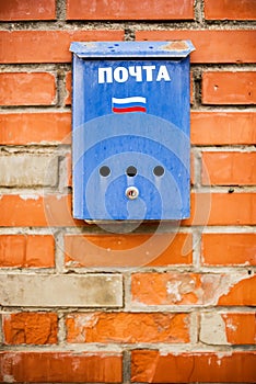 Blue mailbox on a brick wall, russian post, russia flag