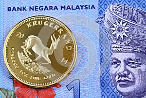 Blue Malaysian one ringgit bill with a gold Krugerrand coin