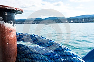 Blue marine rope on ship with lake water and landscape