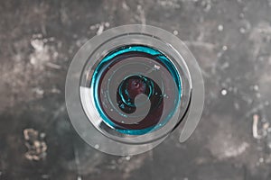 Blue martini cocktail with cherry on the rustic background