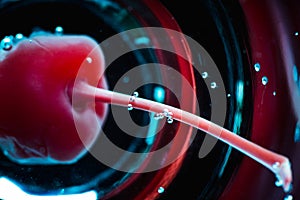 Blue martini cocktail with cherry on the rustic background