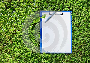 Blue medical clipboard over green grass