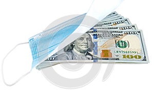 Blue medical face mask and stack of 100 USD banknotes isolated on white background