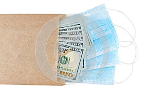 Blue medical face masks and stack of 100 USD banknotes in brown paper packet isolated on white background