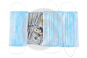 Blue medical face masks and stack of 100 USD banknotes. Isolated on white