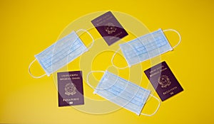 Blue medical facial mask  on a yellow background and italian passports.