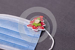 Blue medical mask with christmas tree-shaped clothespins. new years medical flatly photo