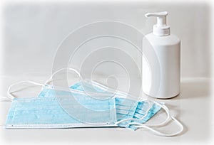 Blue medical mask and hand sanitizer gel or soap dispenser. Coronavirus prevention concept