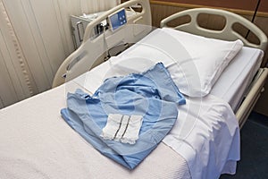 Blue medical operation shirt and white operation underware lying on a hospital bed