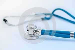 Blue medical stethoscope or phonendoscope on white background