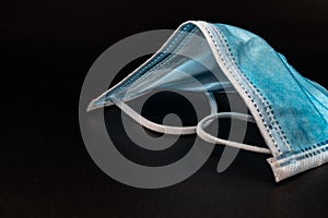 Blue medical or Surgical face Mask. Virus Protection. Black background. Space for entering text photo