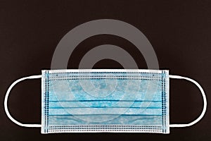 Blue medical or Surgical face Mask. Virus Protection. Black background. Space for entering text photo