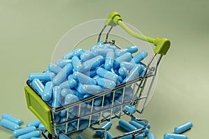 blue medicine capsule in miniature shopping cart