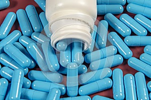 blue medicine capsules and white bottle