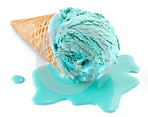 Blue melted ice cream in waffle cone on white background. Melt ice cream puddle near cone with ice