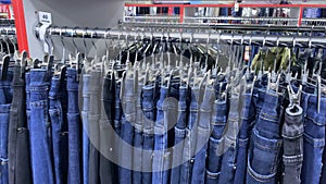 Blue men jeans on hangers in shop,  clothes on hangers in store