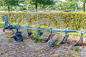 Blue metal agricultural tractor plow in a farm yard