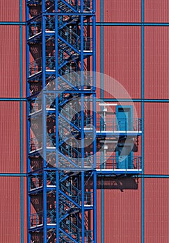 Blue metall staircase on red industrial building