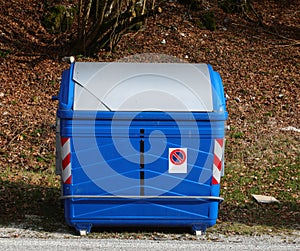 blue metallic bin for the collection of solid urban waste and no parking photo