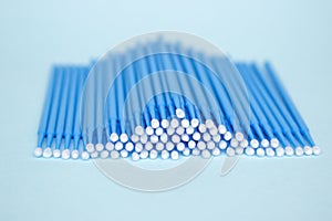 Blue microbrushes, small brushes for cleaning eyelashes and teeth. Blue background. Dentistry, eyelash extensions