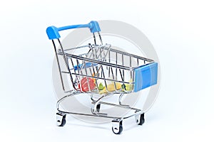 Blue mini grocery cart from supermarket with groceries on white background. Consumer concept