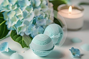 Blue mint bath bombs with hortensia on white table, lit candle