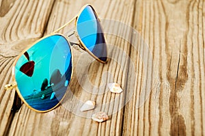 Blue mirrored sunglasses wiht reflection of martini glass on the