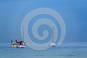 Horizontal  photo of the three boats under the blue misty sky