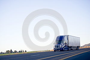 Blue modern semi truck reefer trailer carry cargo on highway