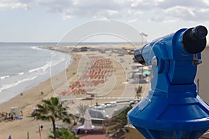 Blue monocular on viewpoint overlooking Playa del Ingles in Maspalomas, Gran Canaria