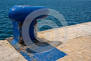 Blue mooring bollard close-up. Empty dock with copy space