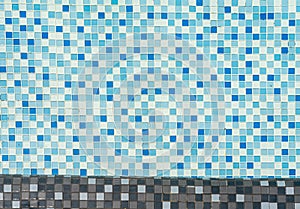 Blue mosaic tiles in swimming pool full of water