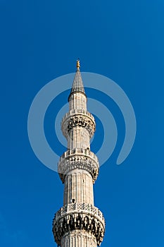 Blue mosque minaret against blue sky on the background