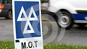 Blue MOT service sign on british road on cloudy rainy day photo