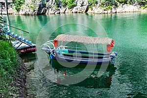 Blue motor boat docked in the small lake bay