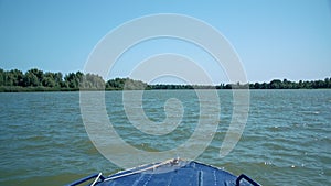 Blue motor boat sailing in the Danube river delta near city of Vilkove