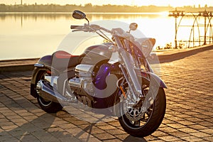 Blue motorcycle stands at sunset on the background of the river