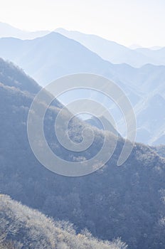 Mountains foggy white blue sky. Chinese autumn mountains.