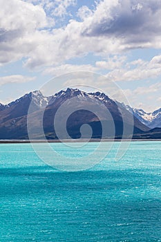 Blue mountains over a lake with turquoise water. Lake Pukaki in the Southern Alps. New Zealand