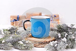 Blue mug with hot tea, coffee or cocoa on winter holidays backg