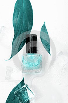 Blue nail polish bottle on white background. Cyan nail polish bottle with blue leaves and ice decor. Eco nail design