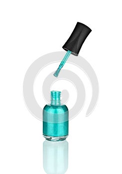 Blue nail polish glass bottle and brush, mirror reflection white background isolated close up, light blue open varnish, turquoise